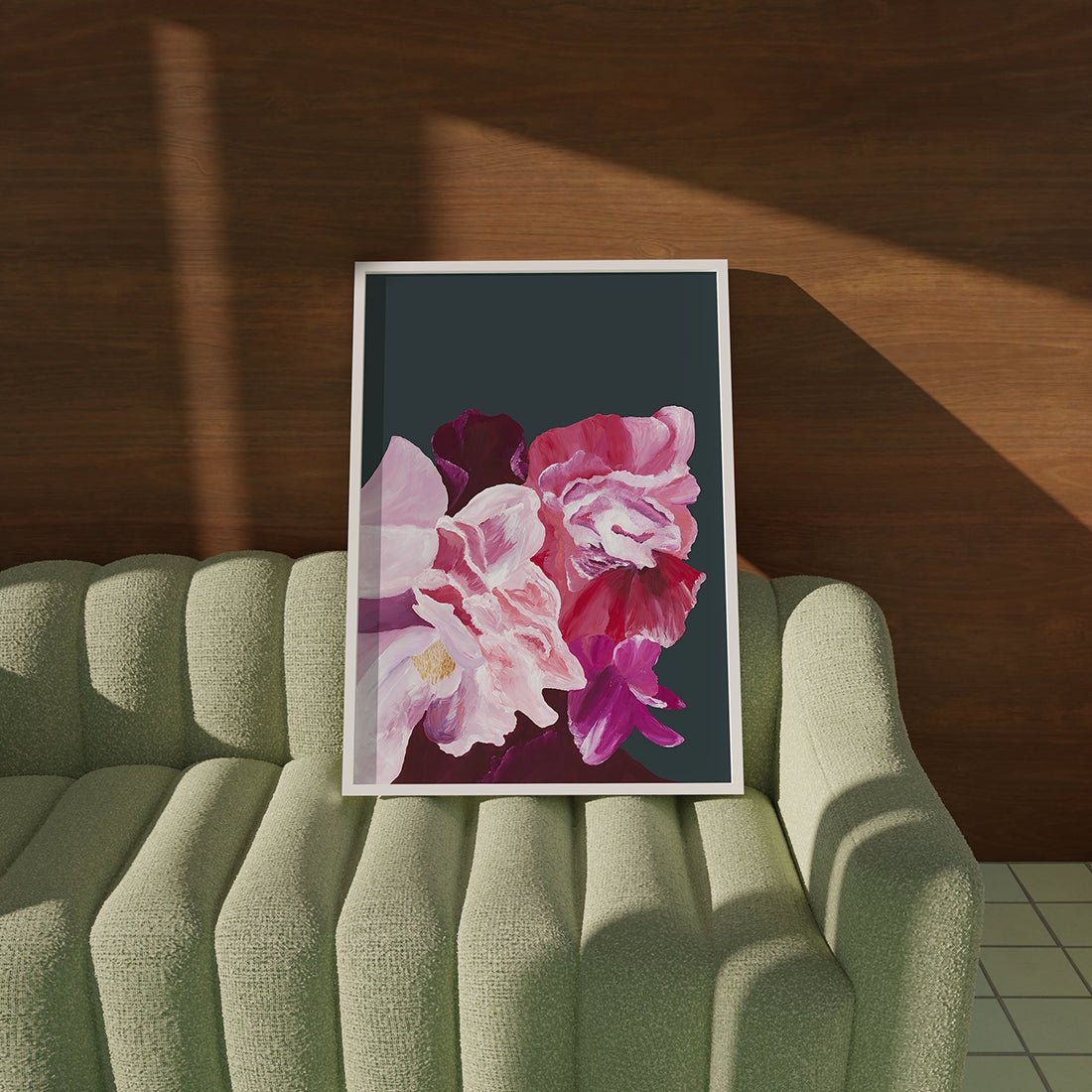 Balanced fine art print of pink flowers showcased on green couch.