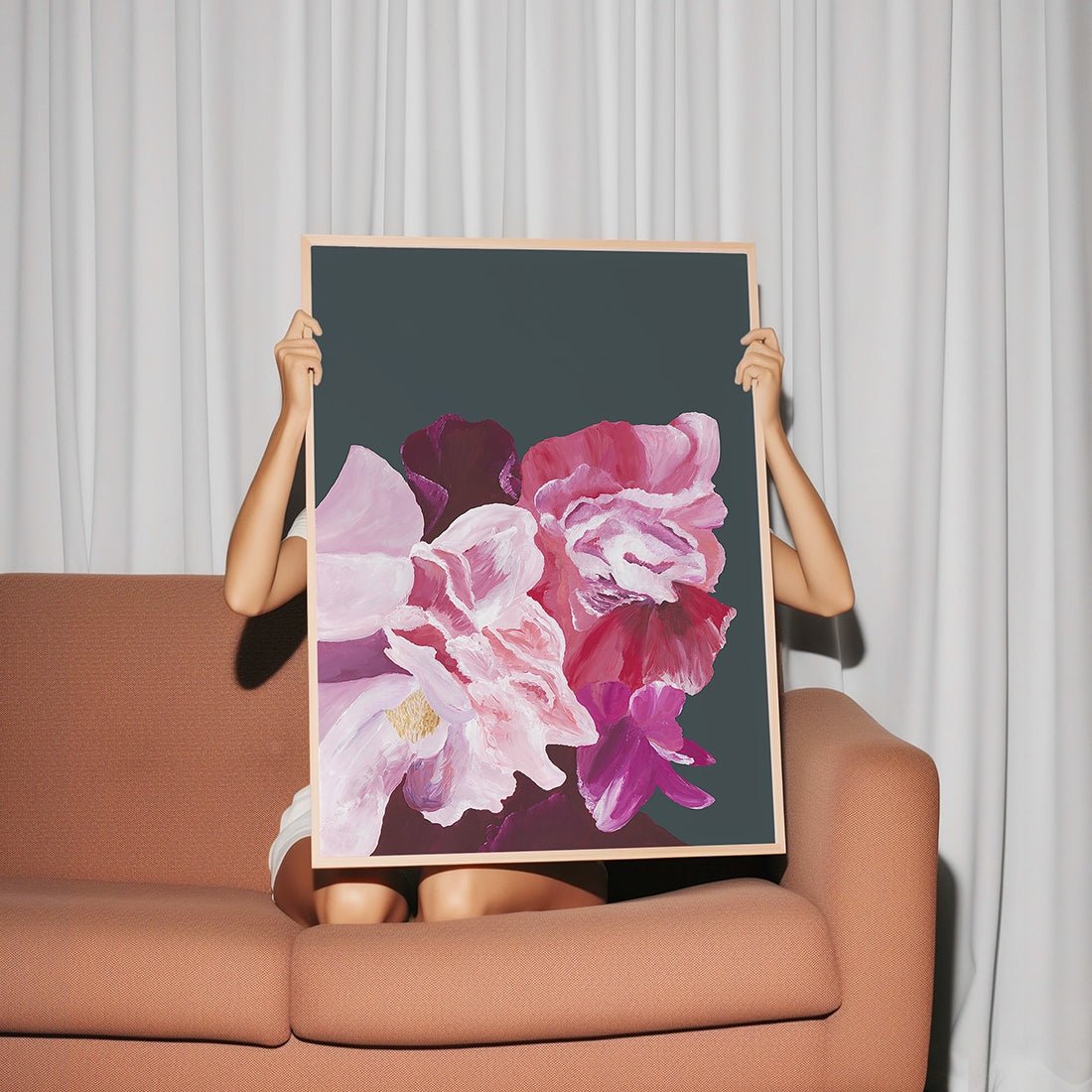 Woman holding a large pink flower fine art print named ’Balanced’.