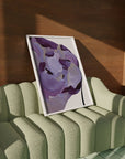 Empire product with purple flower and muted gold accents on green couch for eclectic interiors.