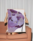 Woman holding large purple abstract painting with muted gold accents for eclectic interiors.